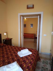 阿格里真托FORESTERIA DEL TEATRO的酒店客房,配有一张床和一张红色的沙发