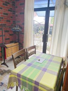 峇六拜Dusun Indah Cottage 2的桌子、两把椅子、桌子和窗户