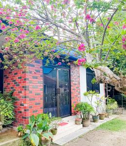 峇六拜Dusun Indah Cottage 2的砖房,上面有粉红色的花