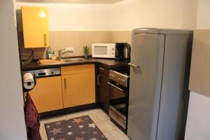 巴特梅根特海姆Haus Buckaroo – Rancho el Rosal的厨房配有不锈钢冰箱和微波炉。