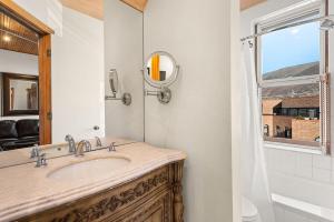 阿斯潘Independence Square Unit 306的一间带水槽和镜子的浴室以及窗户。