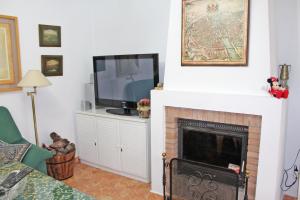 奇克拉纳－德拉弗龙特拉Chalet Carlos El Campito的客厅设有壁炉和电视。