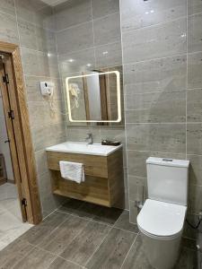 奇姆肯特KORKEM Palace Hotel and Spa的一间带卫生间、水槽和镜子的浴室