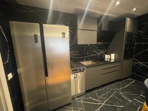 GnjilaneSonny’s Penthouse的厨房配有不锈钢冰箱和电器