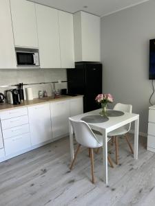 弗罗茨瓦夫Apartament na Dworcowej Centrum的厨房配有白色的桌椅和鲜花桌