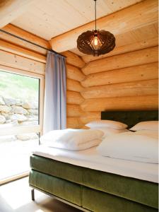 博登迈斯Ahütten的卧室配有木墙内的一张床