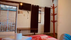 奥兰太坦波Mirador inka的客房设有床、电视和窗户。