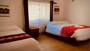 奥兰太坦波Mirador inka的一间卧室设有两张床和窗户。