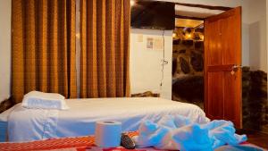 奥兰太坦波Mirador inka的卧室配有白色的床和电视。
