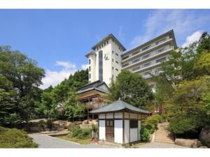 日光Kinugawa Onsen Yusuikiko Hotel Otaki - Vacation STAY 68843v的一座白色的大建筑,前面有一座塔