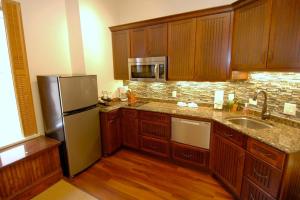 阿斯潘Independence Square 210, Beautiful Studio with Kitchenette, Great Location in Downtown Aspen的厨房配有木制橱柜和不锈钢冰箱。