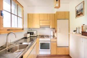 威拉尔-苏-罗伦Rare, quite & centered Apartment with Garden & Fireplace的厨房配有木制橱柜、水槽和冰箱。