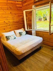 TeavaroBungalow TEIPO的木制客房的一张床位,设有窗户