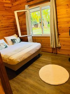 TeavaroBungalow TEIPO的一间卧室设有床、窗户和地毯。