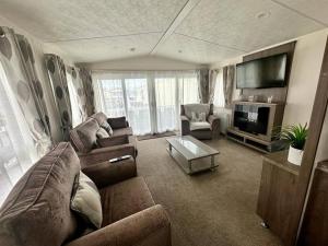 Kinmel Bay6 berth luxury caravan, Lyons Winkups Holiday Park的带沙发和电视的客厅