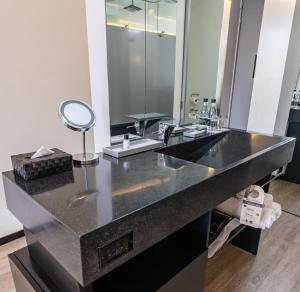 波哥大收集93GHL酒店的一间带黑色镜子的台面的浴室