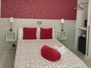 马德里马德里客栈旅馆的一间卧室配有一张带红色枕头和红色枕头的床