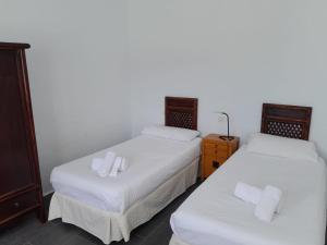 塞博河畔卡莱塔Duplex La Graciosa的配有2张床的客房内配有白色床单和毛巾