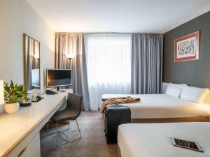 格拉斯哥诺富特格拉斯哥中心酒店的酒店客房配有两张床和一张书桌