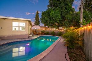 北迈阿密海滩Amazing 3 Bed House with Gameroom and Fun Backyard的夜间在家后院的游泳池