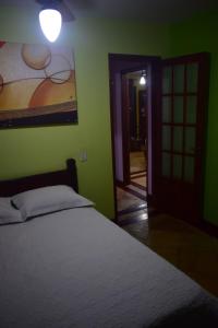 卡波布里奥Casa Verde do Peró的卧室配有一张床,墙上挂有绘画作品
