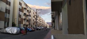 内瓦Apartamento Neiva的一条城市街道,有停车的汽车和建筑