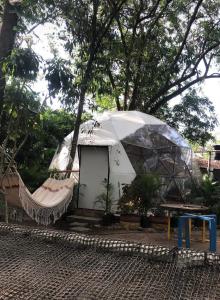 里韦拉Hotel Ambrosia Lodge的庭院内带吊床的白色帐篷