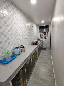 马六甲Homestay Melaka Baitul Saadah的一间厨房,在房间内有长柜台