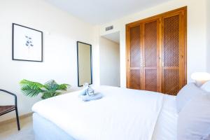 EsteponaTop floor spacious apartment with sea views in Costalita的卧室配有白色的床和毛巾