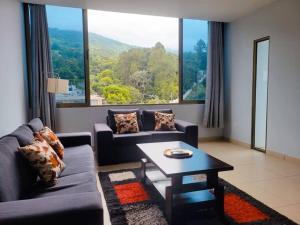 圣萨尔瓦多Los Cielos302: Spacious Condo with scenic views.的带沙发和桌子的客厅以及大窗户。