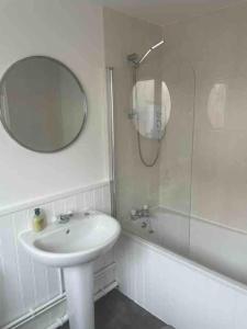 纽尼顿Stylish Property in Nuneaton的一间带水槽、镜子和淋浴的浴室