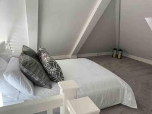 纽尼顿Stylish Property in Nuneaton的卧室配有白色的床和枕头。