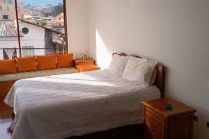 昆卡Cuenca -Sucre Suites Modern Lux的一间卧室设有一张床和一个大窗户