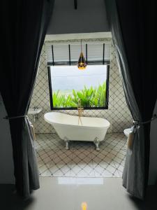 Ban Wang Dinริมยมรีสอร์ท的一间带大窗户和浴缸的浴室