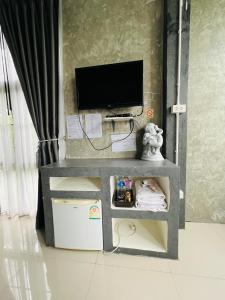 Ban Wang Dinริมยมรีสอร์ท的客厅配有电视和带电视的桌子。
