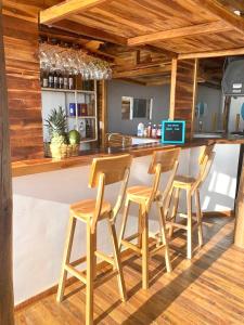 布兰卡滩Solarium Beach Club的厨房里设有四张木凳的酒吧
