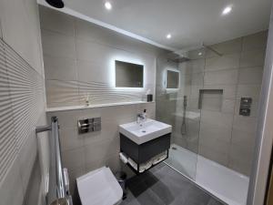 马盖特Sunset Point Apts - Blue Horizon Suite的一间带水槽、淋浴和卫生间的浴室