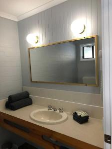 西怀厄朗Country Roads Motor Inn的一间带水槽和镜子的浴室