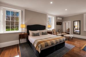 Hagley昆比庄园酒店的一间卧室配有一张床、一把椅子和窗户。