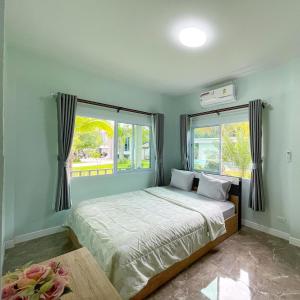 卡农อิงแลนด์เฮ้าส์แอนด์พูล England8House&Pool的一间卧室设有一张床和两个窗户。