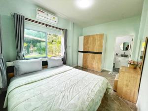 卡农อิงแลนด์เฮ้าส์แอนด์พูล England8House&Pool的一间卧室设有一张大床和一个窗户。