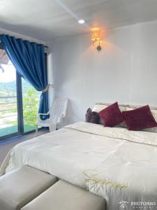 清迈Phutonso Homestay的卧室设有一张白色大床和一扇窗户。