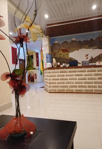 乌尤尼Hotel REY DAVID的大堂的花瓶,桌子上放着鲜花