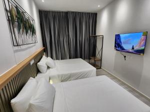 古晋一点酒店的酒店客房设有两张床和一台平面电视。