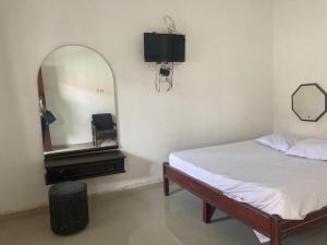 TimuranHotel Surya Citra Jogja A Mitra RedDoorz的一间卧室配有一张床、镜子和电视