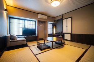 别府Yasuraginoyado Yufu的客厅配有咖啡桌和电视