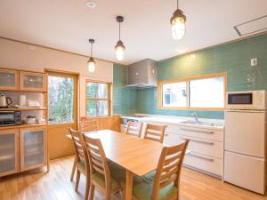 ChikuniKuDo's Lodge - Vacation STAY 85093的厨房配有木桌、椅子和水槽