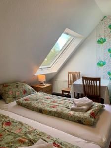 多尔努姆Hotel Pension Schienfatt am Dornumersieler Tief的阁楼卧室设有两张床和窗户。