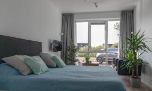 NaarderburenBuitenplaats Wergea的一间卧室配有一张带蓝色床单的床和一扇窗户。