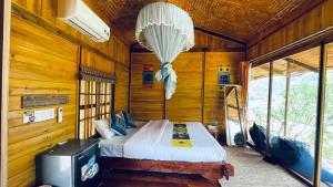 Làng CacDu Gia Panorama的木制客房内的一间卧室,配有一张床